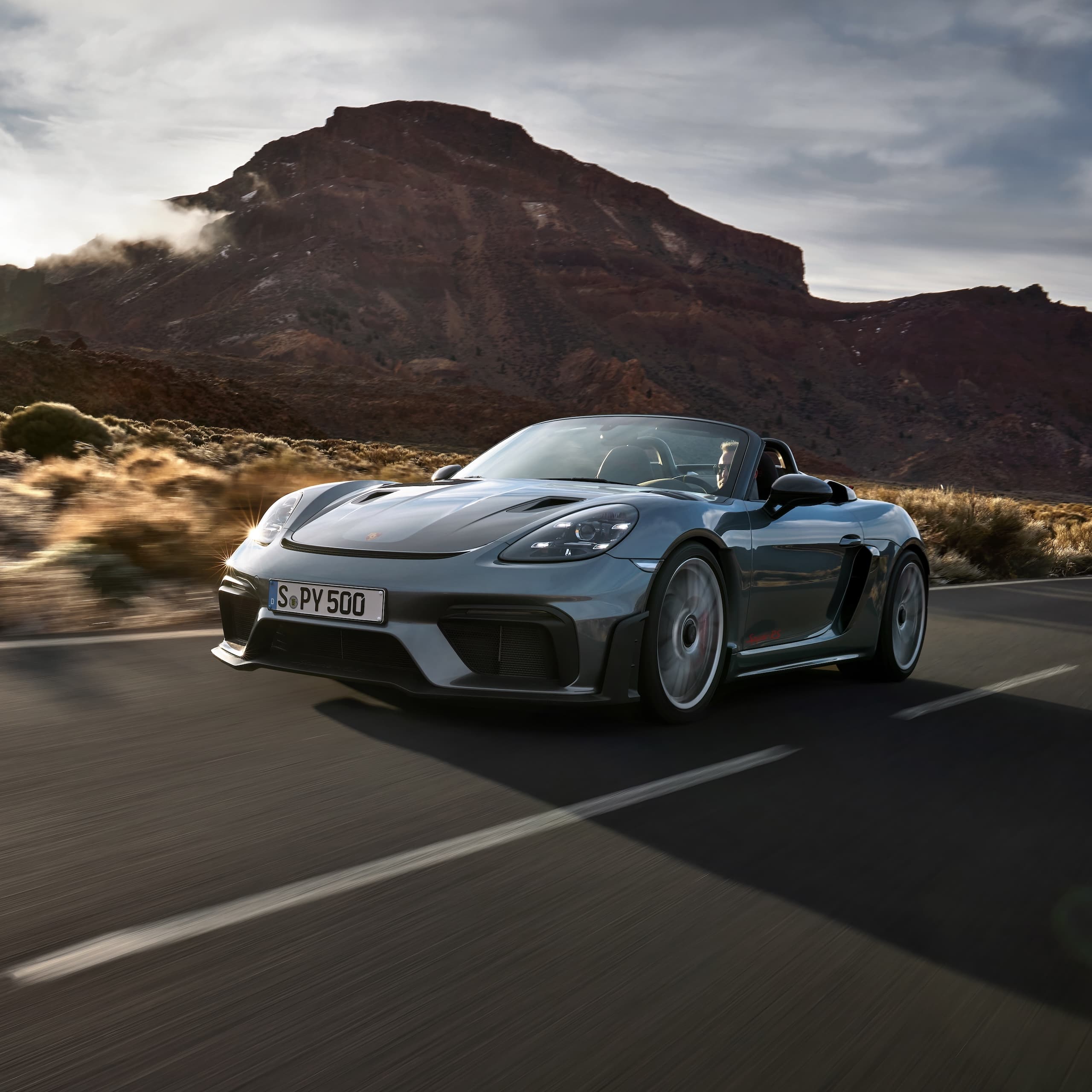 Porsche 718 Spyder RS conduisant sur la route entre les formations rocheuses.